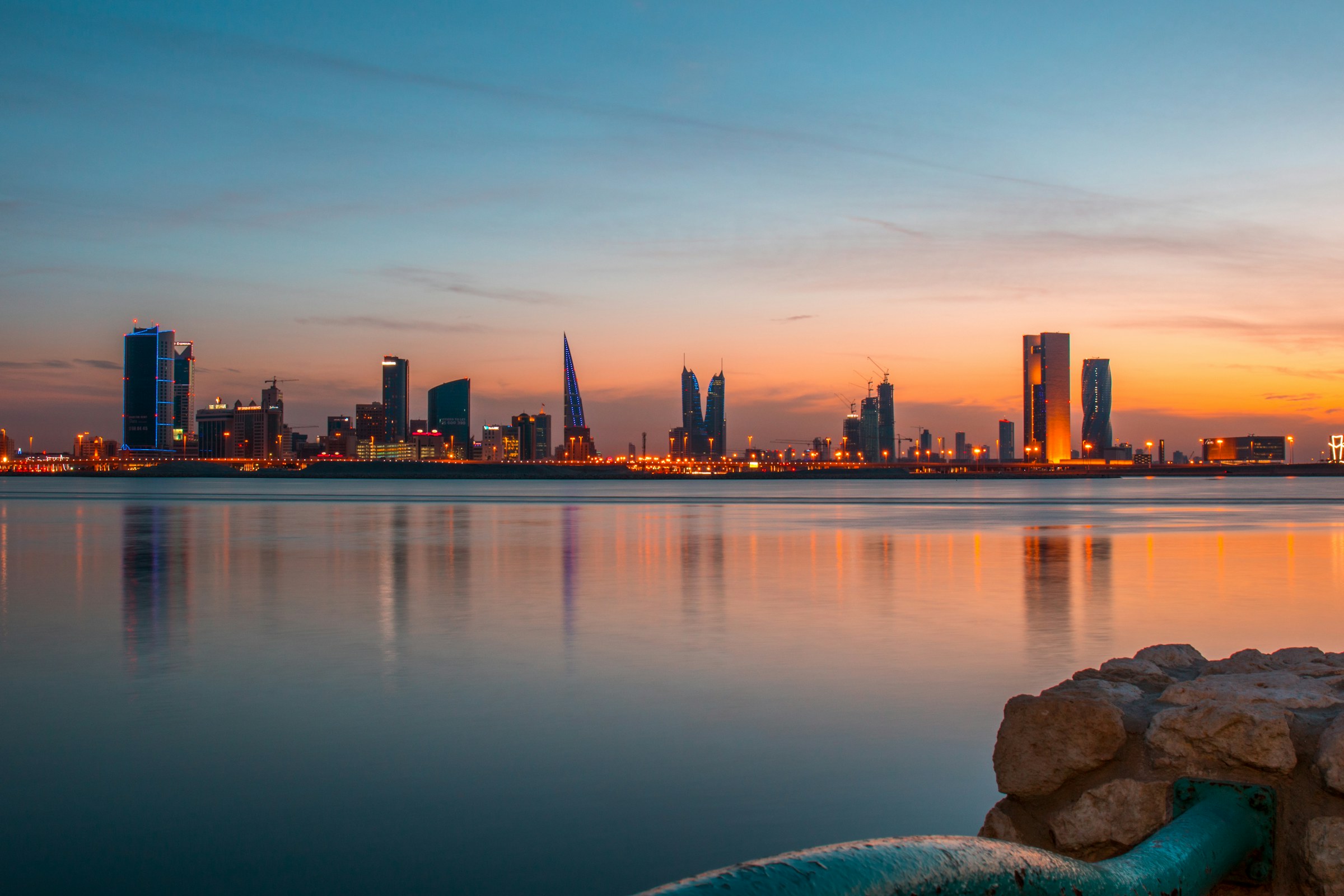 Manama’s waterfront skyline reflected in the sea at sunset