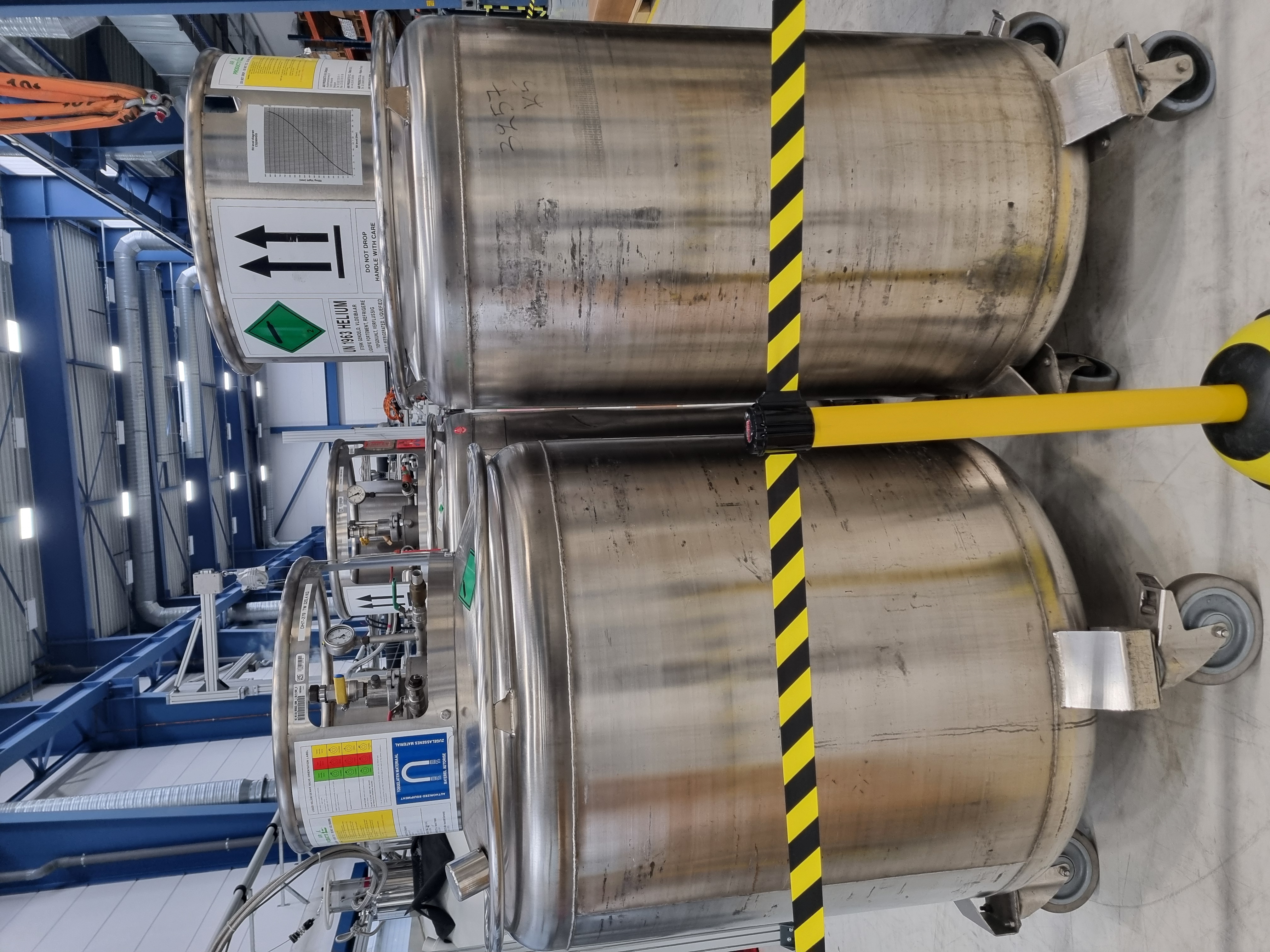 Stainless-steel dewars used to transport liquid helium inside an industrial facility