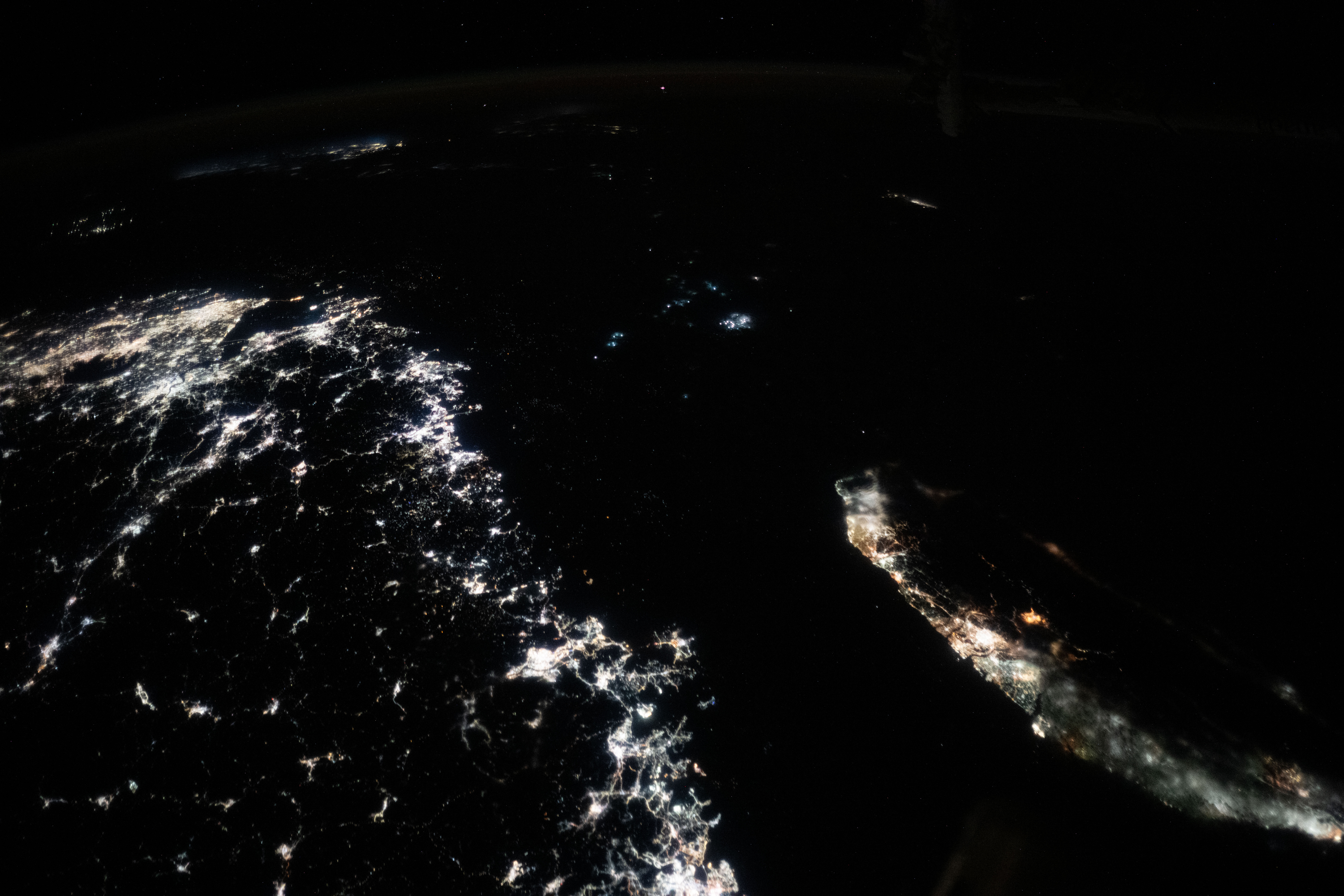 The illuminated coasts of southeast China and Taiwan separated by the Taiwan Strait at night
